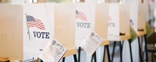 A row of voting booths with American flag VOTE signs